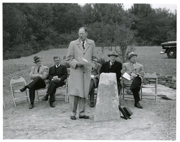 Mr. Fortney speaking.  Seated; Kermit McKeever, Rev. Gutshall, behind speaker Dr. Lambert, Mr. D. D. Brown and C. R. Zarfoss.  Fairfax Stone, Tucker County, West Virginia. Gulley leading from the stone is head spring of the Potomac. The stone is located at the corner of the West Virginia/Maryland boundary 3 miles off U. S. Route 219 between Thomas, West Virginia and Red House, Maryland. The inscription of the bronze plaque embedded in stone written by Dr. D.D. Lambert. State Conservation replaced Fairfax Stone with approximately $2,000.00 appropriated by 1955-1957 legislature. $1,500.00 was from 1955 while $500.00 was from 1957.  