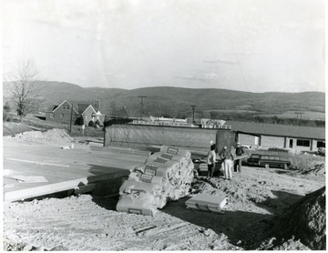 Men working on the construction site for the florist shop owned by Mrs. Hardesty. The Graham house is in the background, center left.
