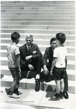 'Small fry get acquainted with two National Youth Science Campers, Paul Wilkens (left) of Castlewood, S. D. and Gary Shimoda of Honolulu, Hawaii, on the steps of West Virginia's state capitol at Charleston.  Wilkens is an All-State basketball player; for Shimoda, this is his first trip to the U. S. Mainland.  The camp, which is held deep in the Allegheny Mountains near Bartow, W. Va. for three weeks ending July 17, brings together the two top science-minded students from every state for lectures and seminars at research and professional levels, field trips to study the state's natural wonders, and side trips to the National Radio Astronomy Observatory at nearby Green Bank and the state and nation's capitols.  The state of West Virginia sponsors the camp.'