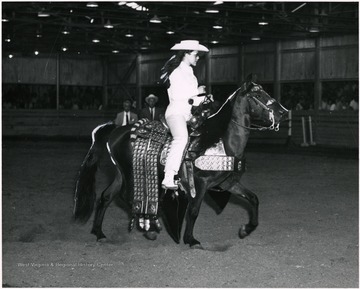 Candy Chidester riding a horse in an arena.
