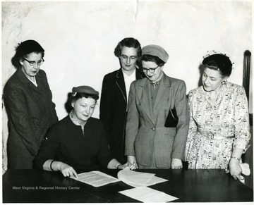 'From left to right: Mrs. Carl Johnson, Mrs. John Schuster, Mrs. J. R. Cresswell, Mrs. L. H. Palmer.  Seated is Mrs. C. L. DeLaney, Chairwoman.'