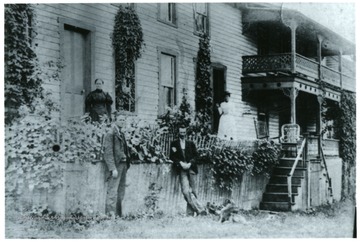 View of Thornton De Vault's home formerly Arlington Hotel.  Pictured- Mr. and Mrs. Thornton De Vault and family, Ira De Vault, Rosetta De Vault and Nancy Ann Prickett DeVault in the black dress.