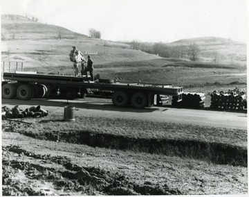 Unloading pipes from a flat bed truck.