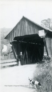 View of man and dog at east end of bridge.