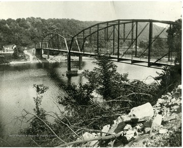 'Cheat River Bridge after the other washed away in 1918.  This was not built upon the same piers and was a short distance further north.  The old one went across from bluff to about where the shelving rock goes out (people swim and fish there now).  Toward Mont Chateau.  This same bridge was raised and added to when lake went in in 1926."
