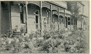 Front view of Experiment Station with man standing on porch.