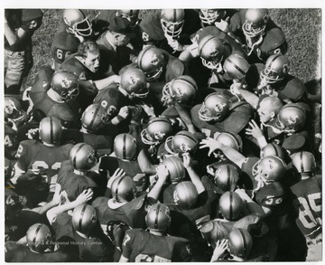 Football players show pre game enthusiasm before a West Virginia University Football Game. "Taylor Publishing Company, Job Number 07206, Picture Number 1, Page Number 190. West Virginia University, Morgantown, West Virginia.'