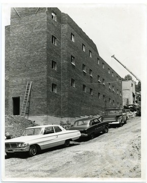 Cars are parked near the construction of Carlisle Hall, West Virginia University.