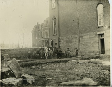 Men standing at north side of Woodburn Hall.  Martin Hall visible in background.