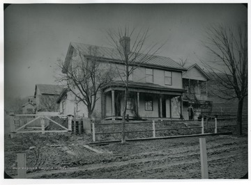 Man is standing near the front porch of Fife Cottage, West Virginia University.