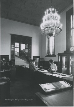 View of woman working at main desk at library.