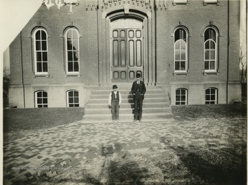'Yoko and the late George Simmins who was the janitor here (WVU) in 1897. Taken in front of Woodburn Hall. Simmins is an engineer in Charleston at the present time. He taught the colored school in Morgantown for a number of terms.'