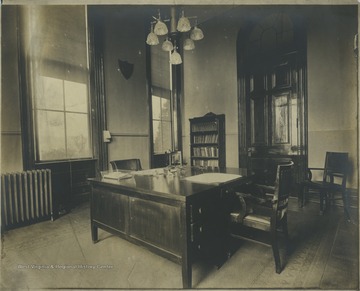 Office in Woodburn Hall featuring telephone and electric or gas lighting, along with standard furnishings.