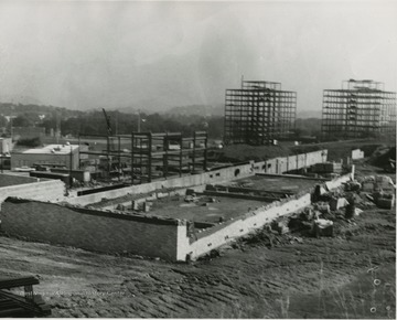 Foreground view of construction of Forestry building.  Background, right, construction of Twin Towers.
