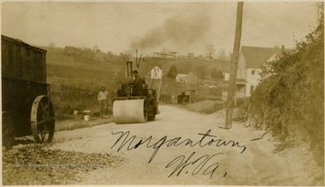 A Steamroller and its operator are pictured.