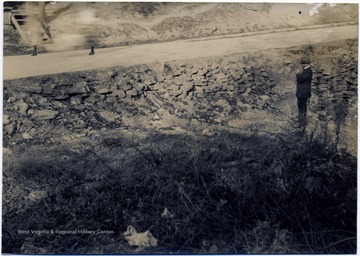 Man standing below a newly constructed road.
