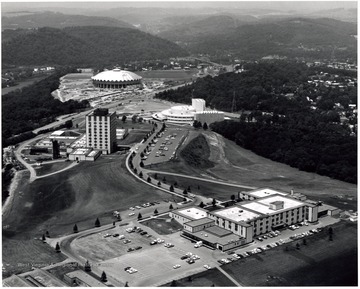 'West Virginia University's Evansdale Campus -- one of the three Morgantown campuses -- sprawls from the banks of the Monongahela River almost to the Medical Center. Buildings shown (from river to foreground) are the Coliseum (under construction,) the Creative Arts Center, the Engineering Sciences Center and the Agricultural Sciences Building.'