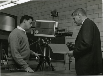 'Dr. Jay Barton, (right) Chairman of the WVU Biology Department, outlines to TV cameraman John Stone of Morgantown, the 50 minute lecture, he will tape for the Biology I course. As soon as it is completed, Barton will have the opportunity to watch a re-play of the lecture and can, if he chooses, change parts of it.'