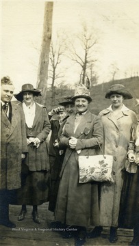 C. G. Barbe standing center with hand bag.