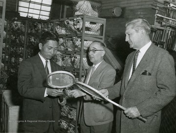 Dean Duncan and others examining tennis rackets.