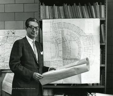 Dean Duncan standing in front of architectural plans for the Creative Arts Center.