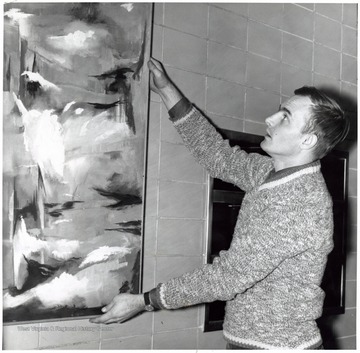 Joe Moss positioning a painting.
