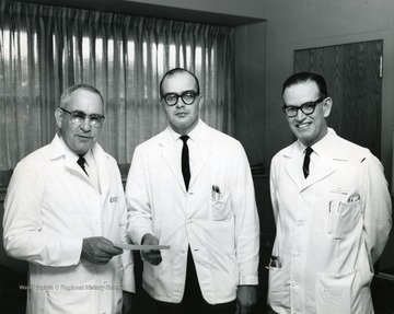 Left to Right:  Dean of Medicine Clark Sleeth, Charles Baise (?), and Dr. Quintero, Head of Allergy Research.
