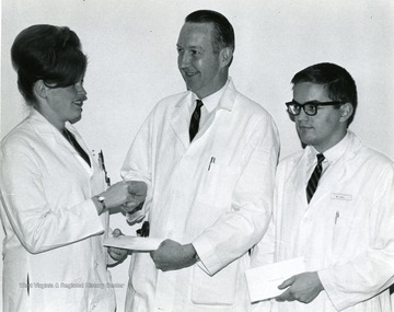 Left to right, Lange; Dr. Morgan, Head of G. at Medical Center, receiving an award; W.L. Hall.