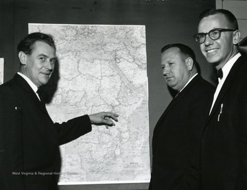 Right to left, Dr. Ralph Nelson, Dr. Robert Dunbar Jr., unidentified man pointing to a map of Africa.