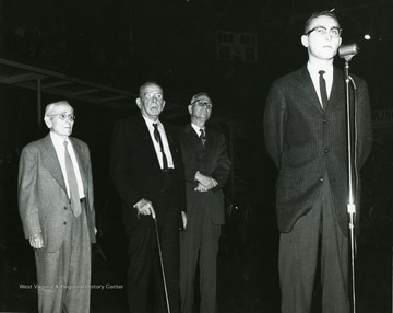 Faculty Day program-half time VMI-WVU Basketball game, February 13, 1959 honoring the three profesor emeriti of West Virginia University. From left, Dr. A. M. Reese, Dr. John B. Grumbein, Dr. Oliver P. Chitwood.