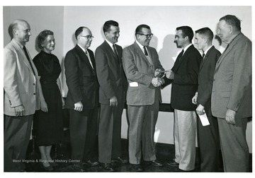 'Left to right: C.P. Dorsey (state 4-H club leader), Mrs. Mary Rose Jones (Assistant Professor of Home Economics, Chairperson Aids and Grants Committee, College of Agriculture Forestry and Home Economics), Dr. A.H. Van Landingham (Acting Dean, College of Agriculture and Forestry and Home Economics), G.W. Melvin (Representative, Esso Standard Oil Company, Morgantown, W.Va.), M.F. Kennedy (Representative, Esso Standard Oil Company, Fairmont, W.Va.), Edwin Townsend (Wood County, Senior, College Agriculture, Forestry, and Home Economics), John Wolfenbarger (Greenbrier County, Freshman, College of Agriculture, Forestry and Home Economics), J.O. Knapp (Director, Agricultural Extension Service, West Virginia University).'