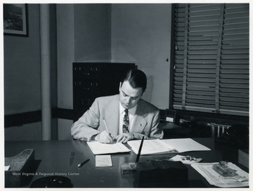 Harry Ross Varney writing at his desk.