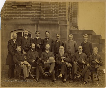 The faculty in the back row, left to right, are named as the following:  John Harvey, Professor of Modern Language; R. C. Berkeley, Professor of Language; James Wilson, Professor of Math and Military; P. B. Reynolds, Professor of English; A. R. Whitehill, Professor of Chemistry; I. C. White, Professor of Geology; and W. P. Willey, Professor of Law.  The faculty in the front row, listed left to right, are named as the following:  St. George Tucker Brooke; D. B. Purinton, Professor of Metaphysics; Pres. E. M. Turner, Professor of Rhetoric; Okey Johnson, Professor of Law; A. Lorentz; and T. S. Stewart, Professor of Mathematics.  The subjects in the photograph were identified by Mr. Bayles and Dr. Callahan.