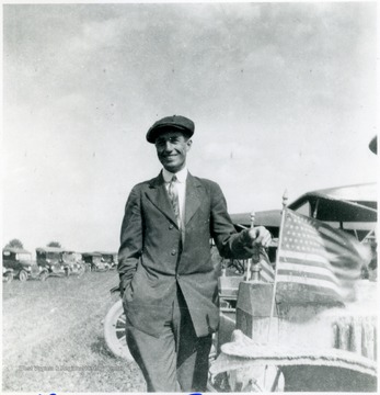 George Green standing beside a car with American flags.