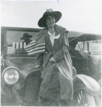 Bernice Green leaning against a four cylinder Dodge car.