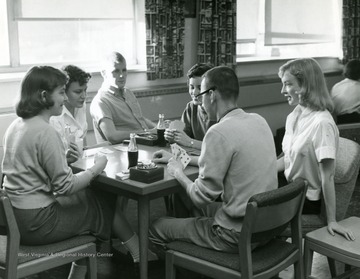 Students playing cards and drinking soda at the Wesley Foundation.