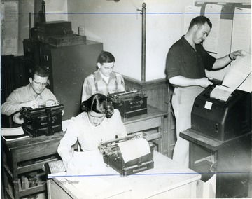 West Virginia University School of Journalism students working with typewriters and teletype machine. 