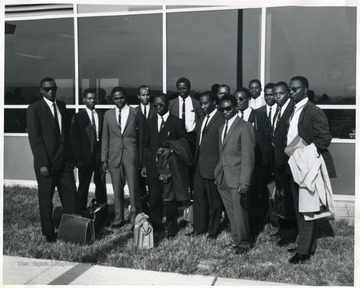 Group portrait of African students standing with luggage.