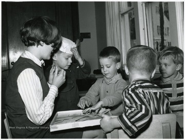 Female student and four boys in nursery.