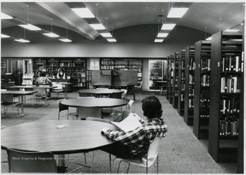 'Library on ground floor, moved downstairs to the bookstore ca. 1979. Mrs. Frank at the circulation desk.'