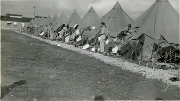 WVU R.O.T.C. cadets at Summer Camp, a row of tents and items of clothing hanging off from the supporting lines are shown.