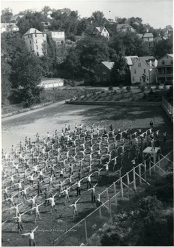 Cadets exercise in a field below Chitwood Hall. During World War II military training at WVU was under the Army Specialized Training Program.
