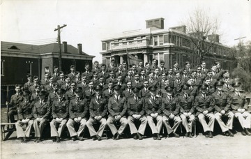 The cadets of company D sit on bleachers with officers for a group photo near Oglebay Hall.