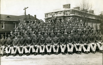 The cadets of company G sit on bleachers with officers for a group portrait near Oglebay Hall.