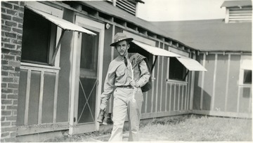 Young man carrying his boots and bag outside.