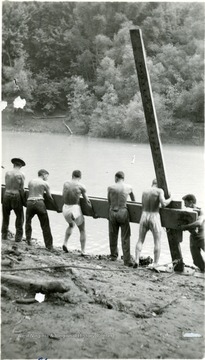 Cadets lifting wooden sections of the bridge.