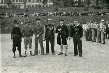 Group of cadets pose for a camera on Old Clothes Day, while onlookers watch them.