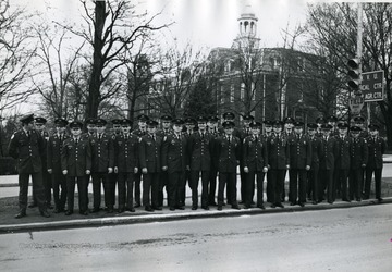 Members of Scabbard and Blade stand in a median across from Stewart Hall.