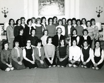 Members of YWCA line up for a group portrait in front of a fireplace in Elizabeth Moore Hall.