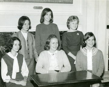 YWCA Officers pose in front of a fire place in Elizabeth Moore Hall; Left rear,  Royce Harworth (Heiskell); center Jennifer Brand.